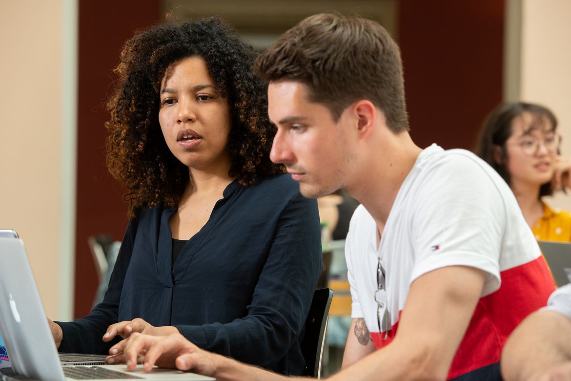 Zwei Studierende besprechen eine Arbeit im Hauptgebäude der UZH.