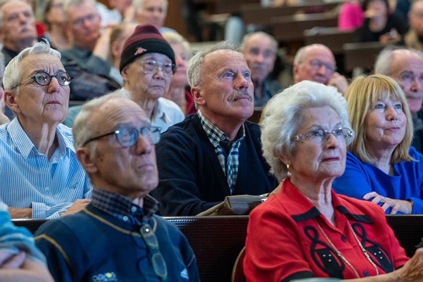 Seniorinnen und Senioren sitzen interessiert im Vorlesungssaal.