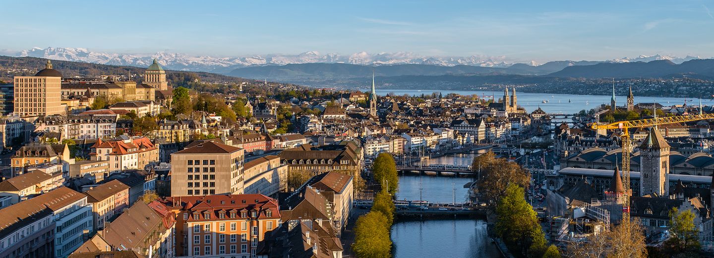You can see the city of Zurich from above and the Alps in the background, the University of Zurich’s tower can be seen on the left.